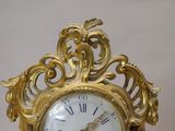 a gold clock that is sitting on a table