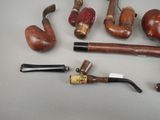 a lot of different types of smoking pipes on the table