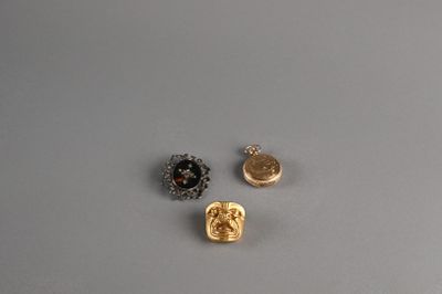 three gold and silver buttons on a gray surface