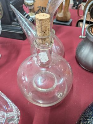 une bouteille en verre avec un bouchon en liège posée sur une table