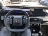 a man sitting in the driver ' s seat of a car