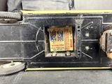 an old radio sitting on the floor next to a piece of luggage