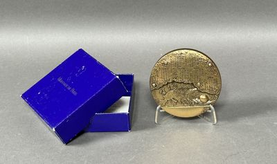un gros plan d'une pièce de monnaie dans une boîte bleue posée sur une table