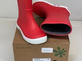 une paire de bottes de pluie rouges posée sur une boîte en carton