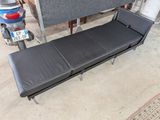 un canapé qui se trouve dans un garage, à côté d'un scooter