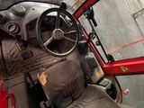 a red car with a steering wheel and a seat in it