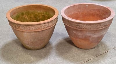 deux pots en terre cuite posés l'un à côté de l'autre sur le sol