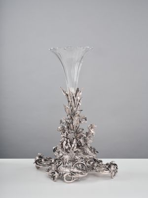 une photo d'un vase argenté posé sur une table blanche