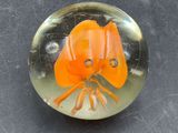 a glass paperweight with an orange flower inside of it
