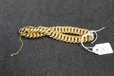 a close up of a gold chain bracelet with a tag on it