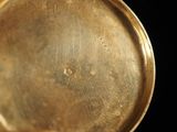 a close up of a gold plate on a black background