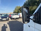 many cars parked in a parking lot with a person taking a picture