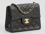 un sac à bandoulière Chanel en cuir matelassé noir, avec des finitions dorées