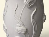 un vase blanc avec des fleurs posé sur une table