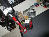 un aspirateur rouge et noir posé sur un bureau, à côté d'autres objets