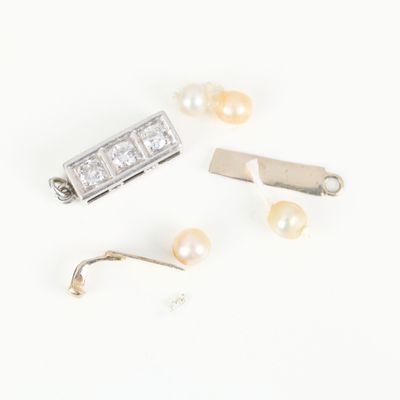 a close up of a pair of earrings with pearls on a white surface