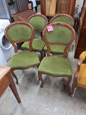 four green chairs are sitting in a room next to a washer and dryer