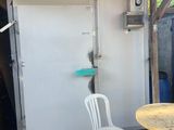 a table and two chairs in front of a white door