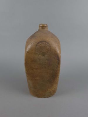 un vase marron avec un couvercle marron posé sur une table