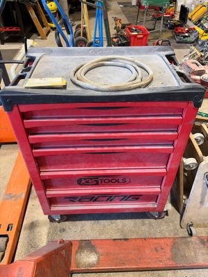 une boîte à outils rouge posée sur une table dans un garage