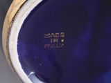 a close up view of a blue vase with a gold rim