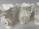 three white vases sitting next to each other on a table