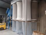 four white vases sitting on a shelf in a warehouse