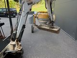 a small excavator that is parked in front of a building