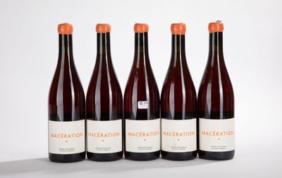 four bottles of wine are lined up on a white surface