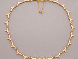 un collier en or orné de petits cœurs sur une chaîne en or