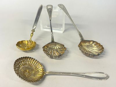 three silver spoons and a bowl are sitting on a table