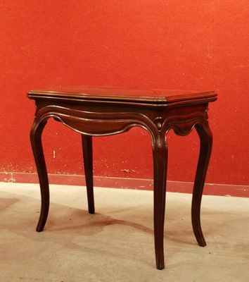 une petite table en bois avec un mur rouge en arrière-plan
