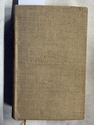 un vieux livre posé sur une table en bois à côté d'un mur