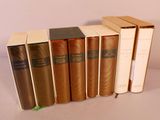 plusieurs livres sont alignés sur une surface blanche