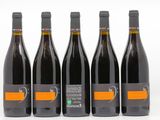 six bouteilles de vin sont alignées sur une surface blanche
