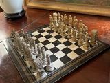 un échiquier posé sur la table, à côté d'un tableau