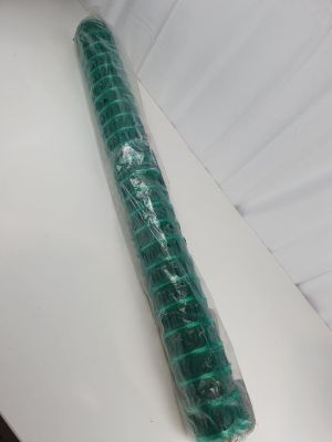 un rouleau de plastique vert emballé dans du plastique, posé sur une surface blanche