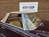 an image of a classic car parked in front of a garage