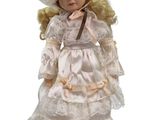 an image of a doll with blonde hair wearing a white dress and hat