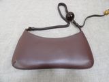 brown leather handbag with gold hardware on strap