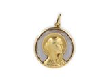 a close up of a gold pendant with a woman ' s face