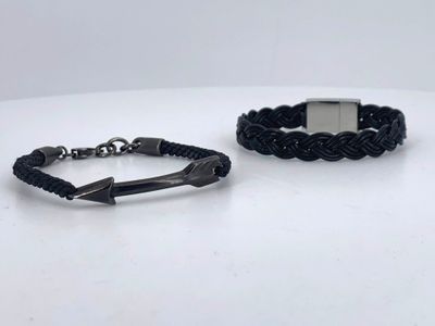 pair of black braided leather bracelets with a silver clasp