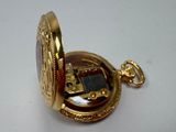 a gold pocket watch with a solar panel inside of it