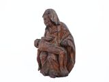 wooden statue of a woman holding a baby in her lap