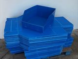 une pile de bacs en plastique bleus posés sur une palette
