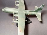 une maquette ancienne d'un avion militaire posée sur une surface grise