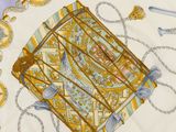 a yellow and blue scarf with a picture of a bird in a cage