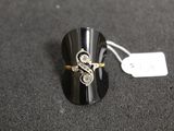 a close up of a ring on a black surface with a price tag