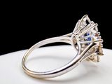 a diamond ring with a blue stone in it on a white plate