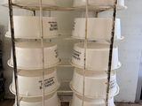 several white buckets stacked on top of each other on a cart